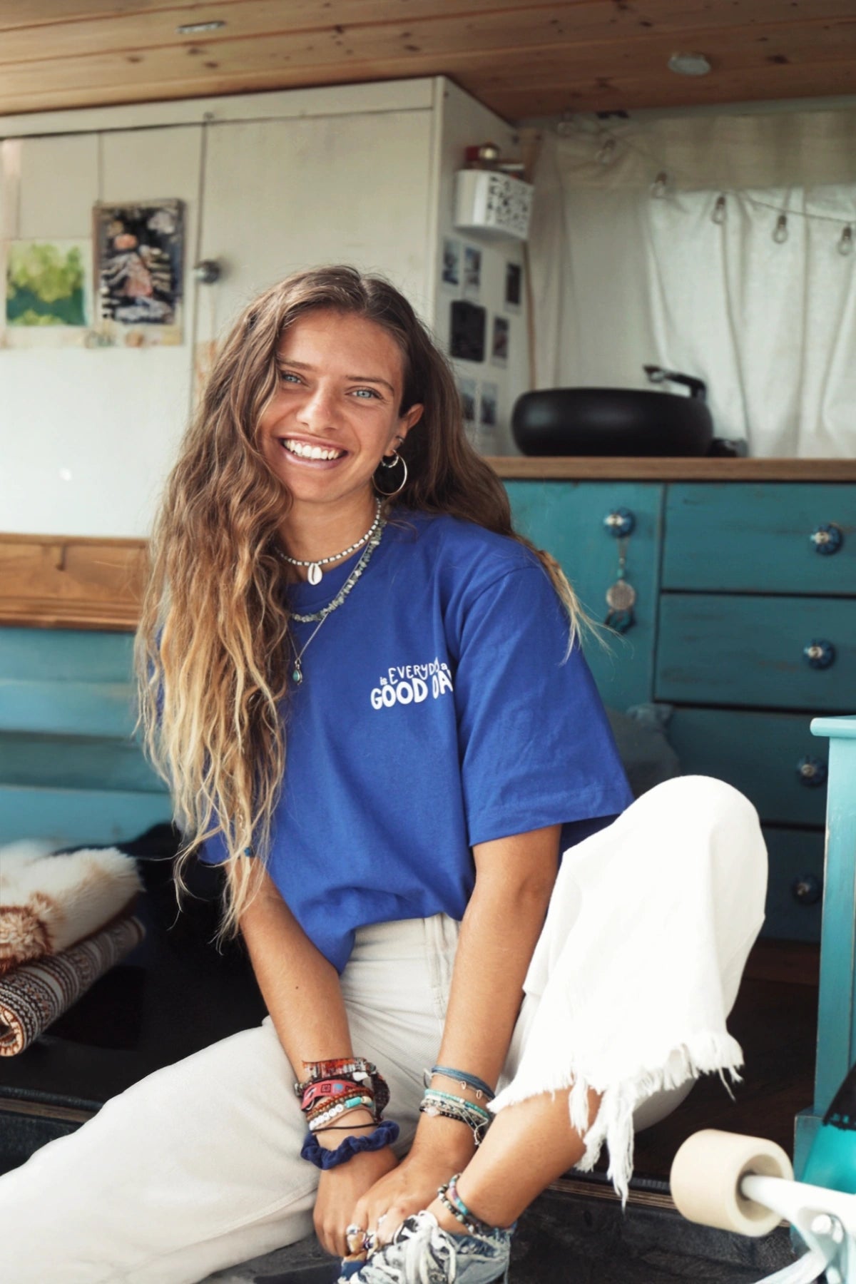 Frau im Van mit blauem Every Day Good Day Oversized T-Shirt – Frontansicht mit Lächeln