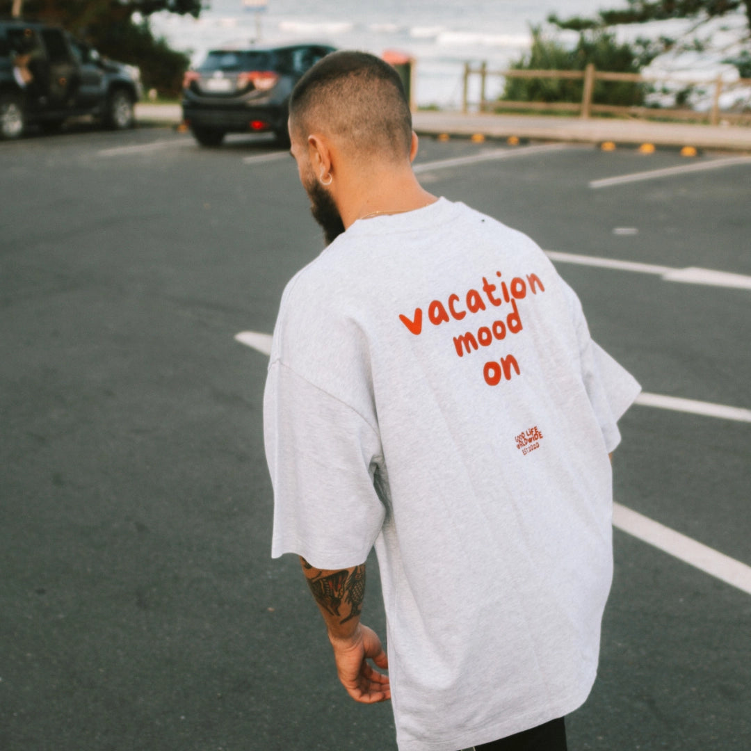 Mann trägt Graußes Oversized T-shirt mit rotem Druck