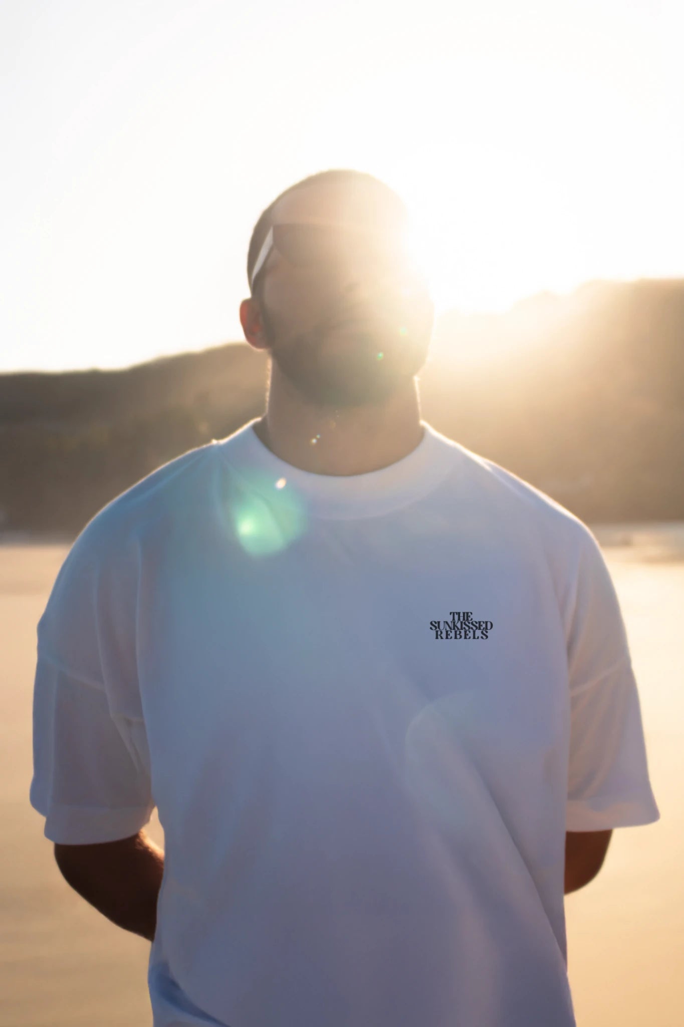 Frontansicht des Oversized T-Shirt Vacation Mood On White von The Sunkissed Rebels bei Sonnenuntergang am Strand