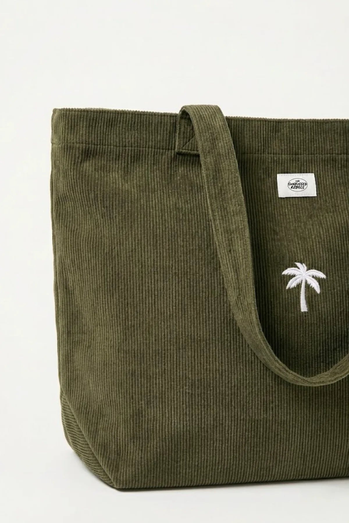 Nahaufnahme der olivgrünen Palm Tree Cord Bag aus Feincord mit weiß gestickter Palme und The Sunkissed Rebels Marken-Patch.