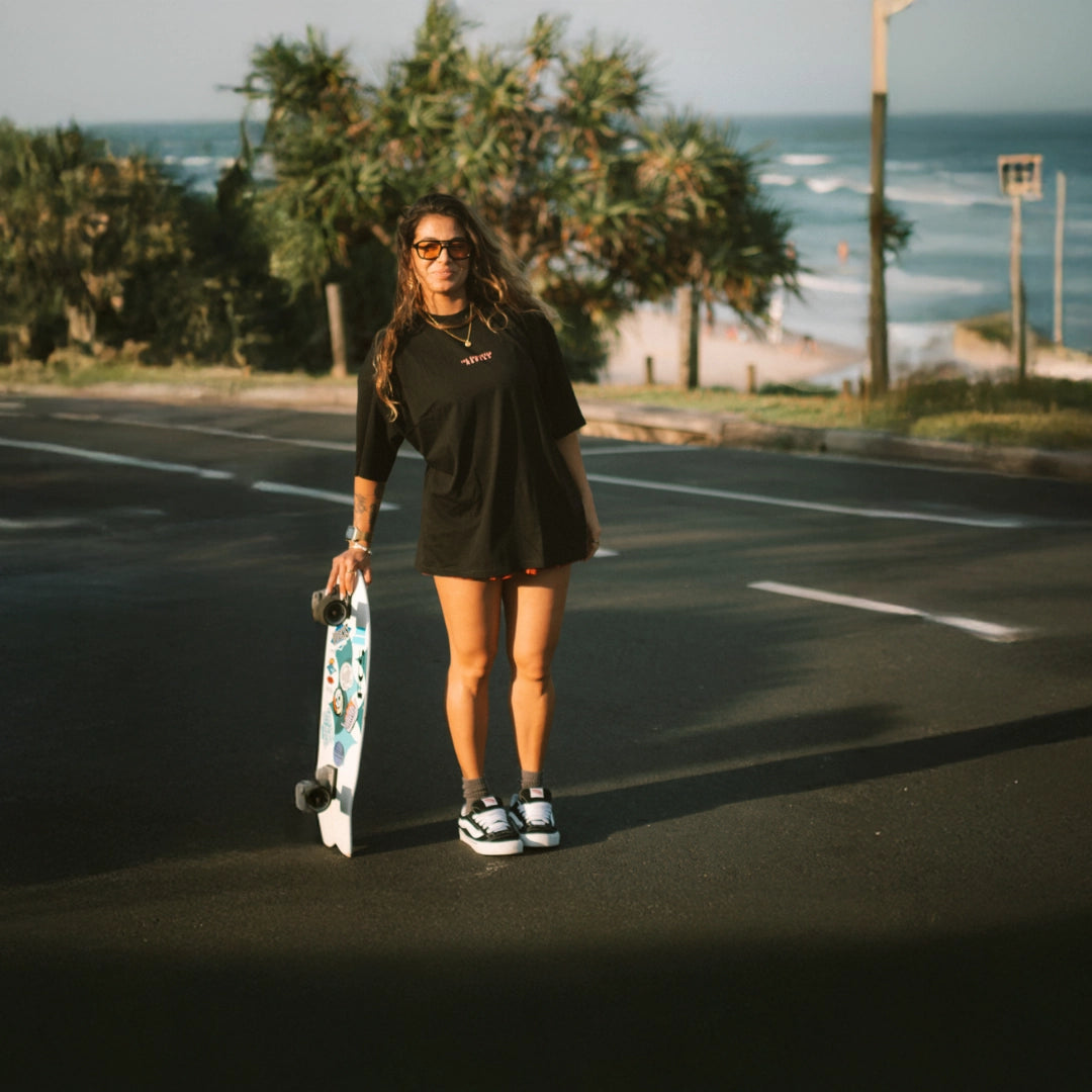 Frau trägt schwarzes Oversized T-Shirt Pinker Stick