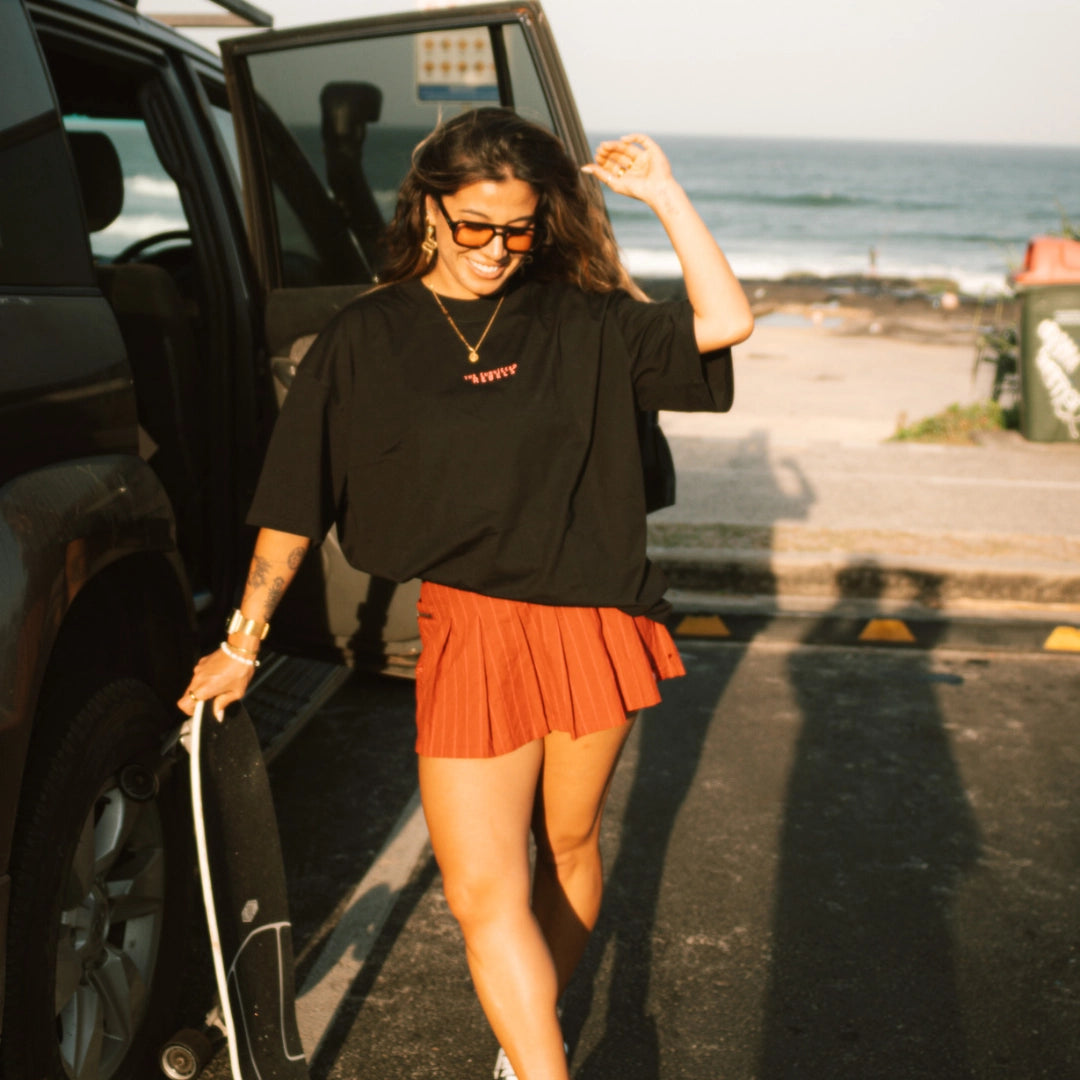 Frau trägt schwarzes OVersized T-Shirt am Strand 