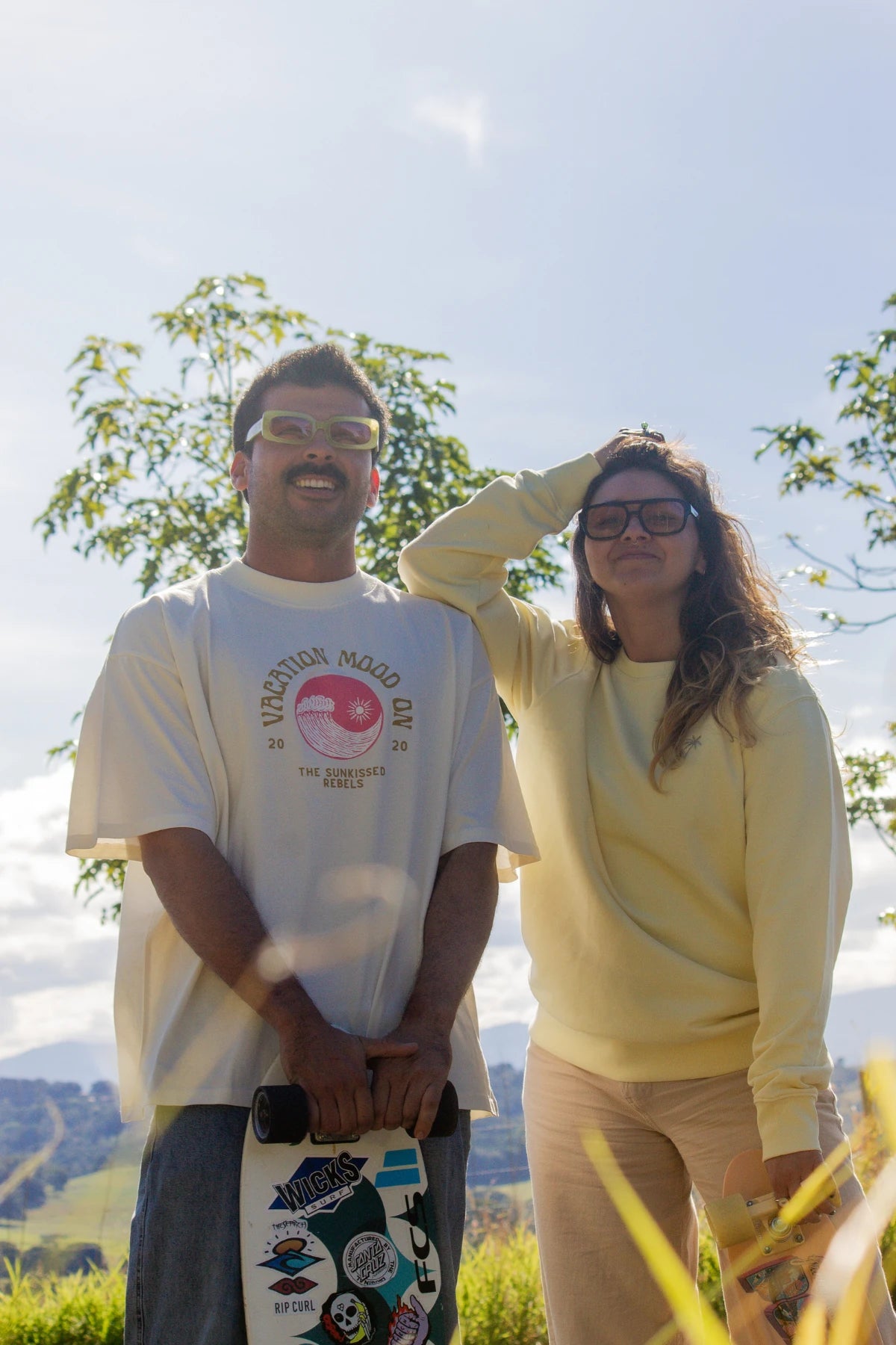 Skater-Couple mit Boards und Sonnenbrillen in der Sonne – Vacation Mood On Cream T-Shirt trifft auf lässige Energie