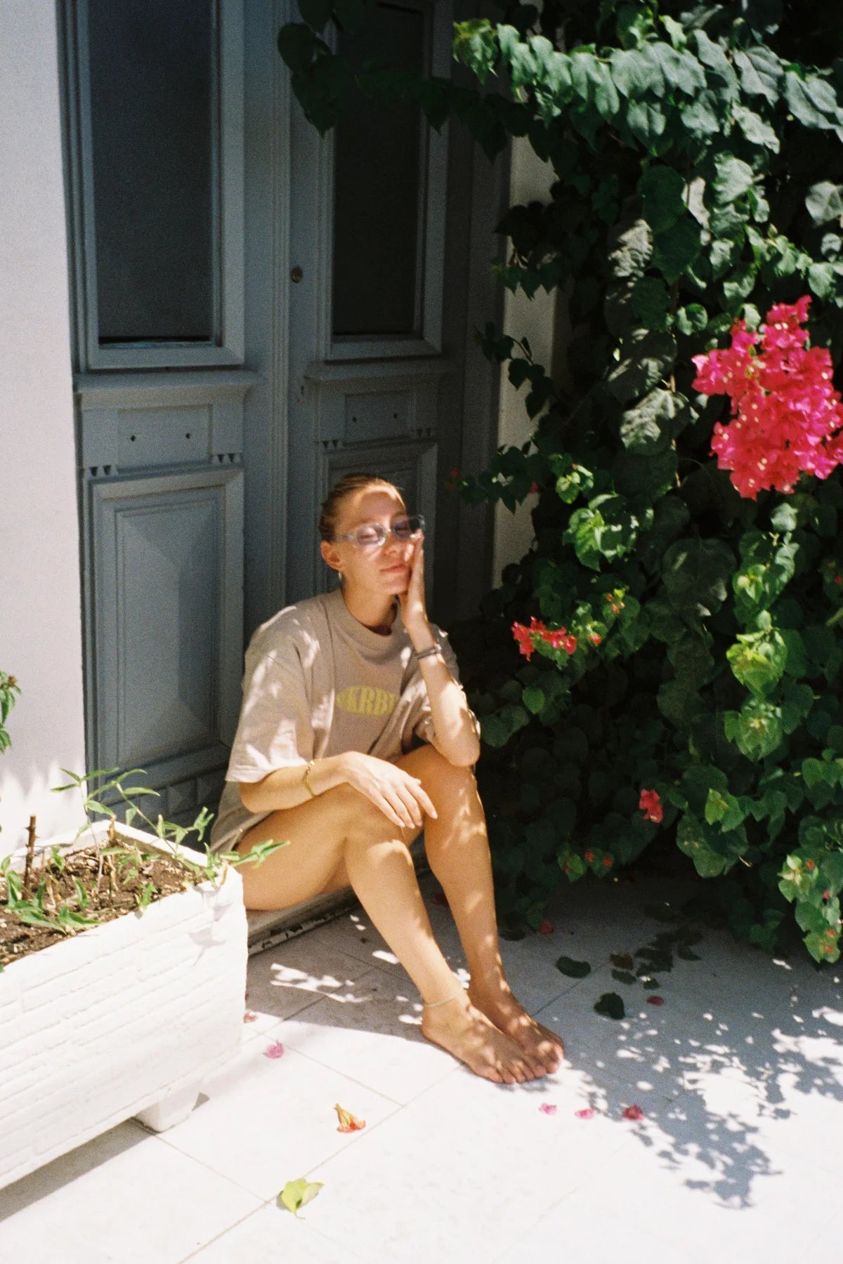 Frau sitzt entspannt im Schatten mit Oversized T-Shirt – lässiger Sommermoment