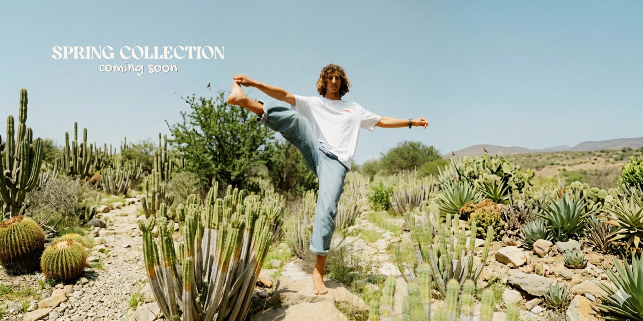 Spring Collection Lifestyle Shooting in der Wüste – Mann im weißen T-Shirt zwischen Kakteen bei sonnigem Himmel