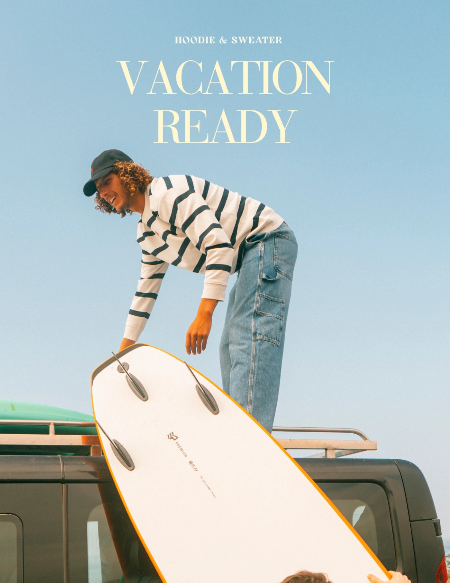 Person steht auf Van mit Surfboard, trägt gestreiften Sweater, sonniger Himmel, entspannter Surf Trip Lifestyle